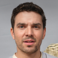 Man with stubble wearing a shirt, looking directly at the camera.